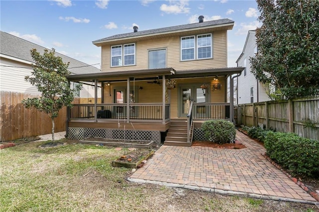 back of house with covered porch, a fenced backyard, and a lawn