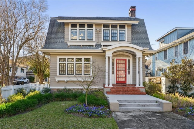 view of front of home featuring a shingled roof, a chimney, and fence