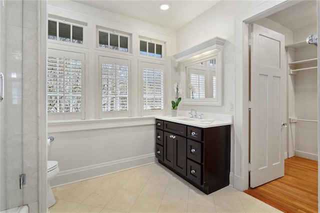 bathroom featuring baseboards, toilet, an enclosed shower, vanity, and recessed lighting