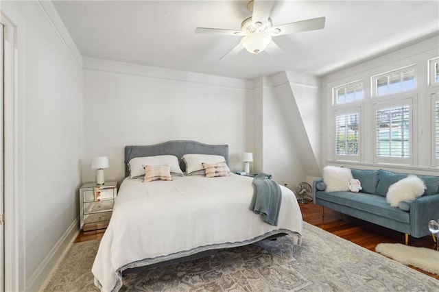 bedroom featuring wood finished floors, a ceiling fan, and baseboards