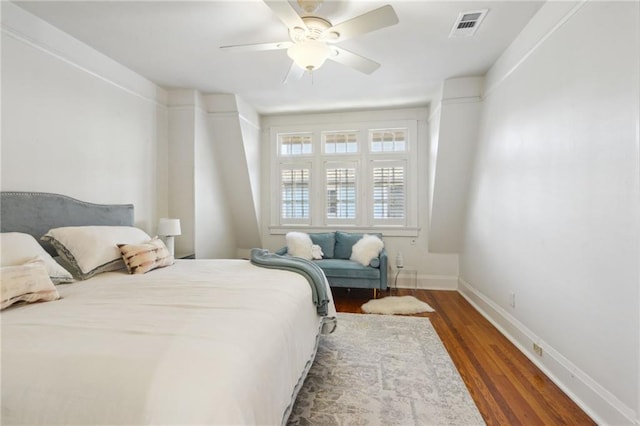 bedroom featuring baseboards, visible vents, ceiling fan, and wood finished floors