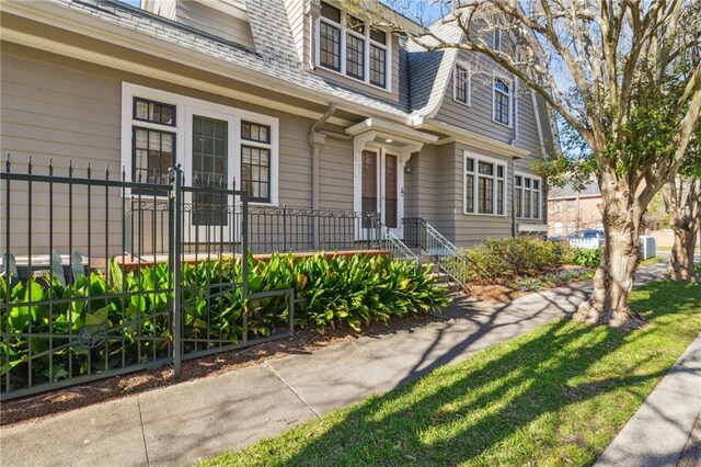 doorway to property featuring roof with shingles