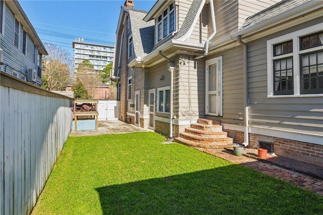 view of yard with entry steps and a fenced backyard