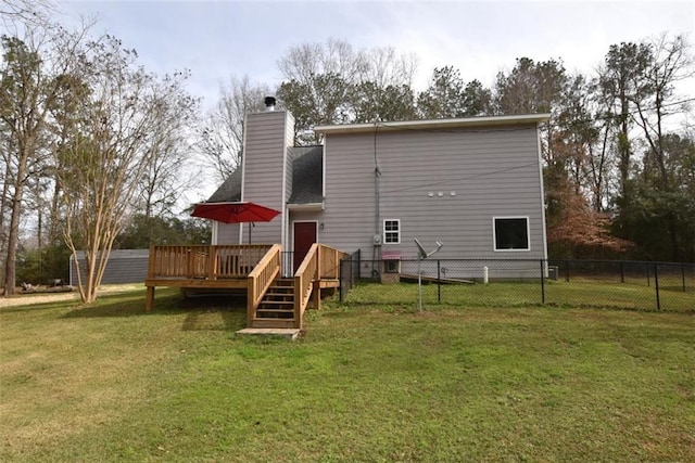 back of house with a lawn, a chimney, a wooden deck, and fence