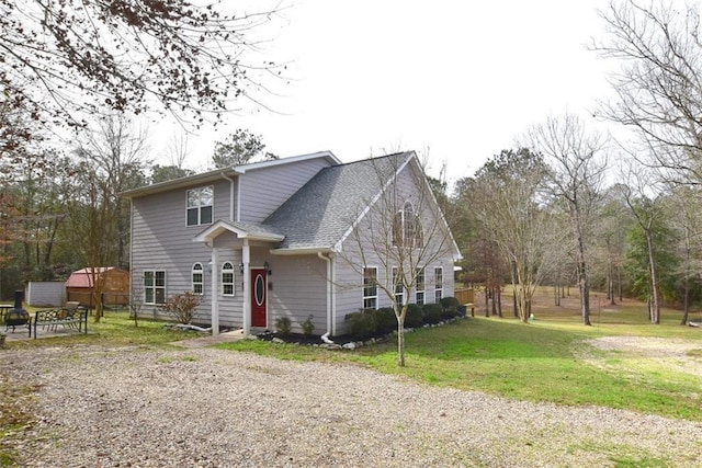 view of front facade featuring a front lawn and roof with shingles