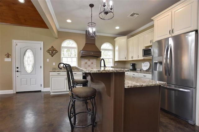 kitchen with visible vents, decorative backsplash, baseboards, stainless steel appliances, and premium range hood