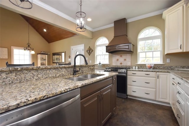 kitchen featuring a wealth of natural light, custom range hood, appliances with stainless steel finishes, and a sink