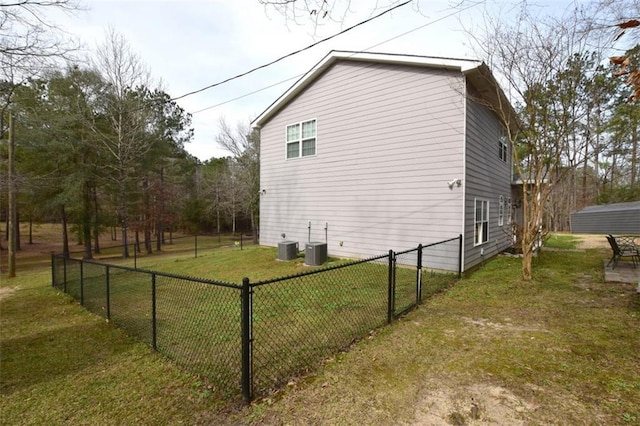 view of side of home with a lawn, central AC unit, and fence