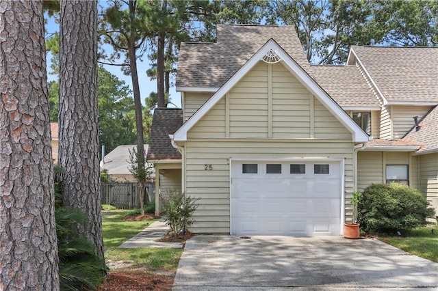 view of front of home with a garage, driveway, fence, and roof with shingles