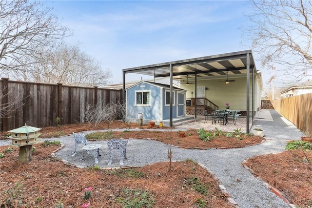 back of property featuring an outbuilding, a fenced backyard, and a patio