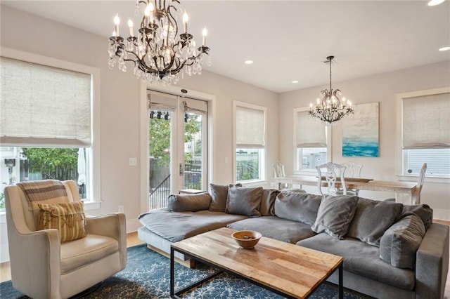 living room with recessed lighting, plenty of natural light, dark wood finished floors, and a notable chandelier