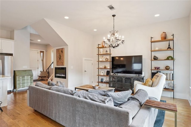 living area featuring light wood finished floors, stairs, visible vents, and recessed lighting