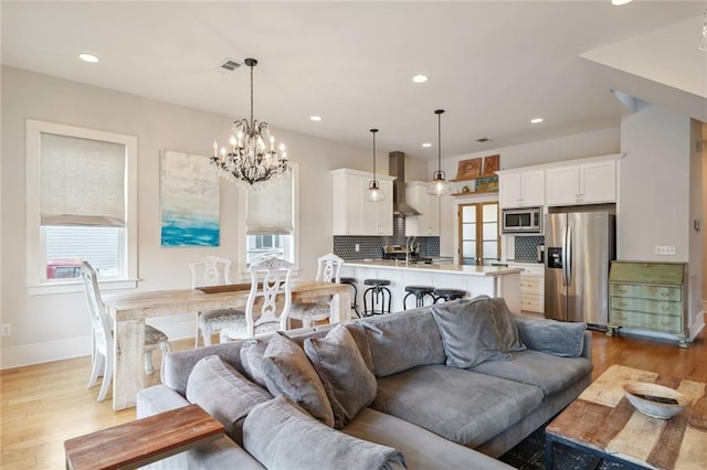 living area with a healthy amount of sunlight, light wood-style floors, visible vents, and recessed lighting