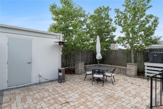 view of patio featuring outdoor dining space, fence, and an outdoor structure