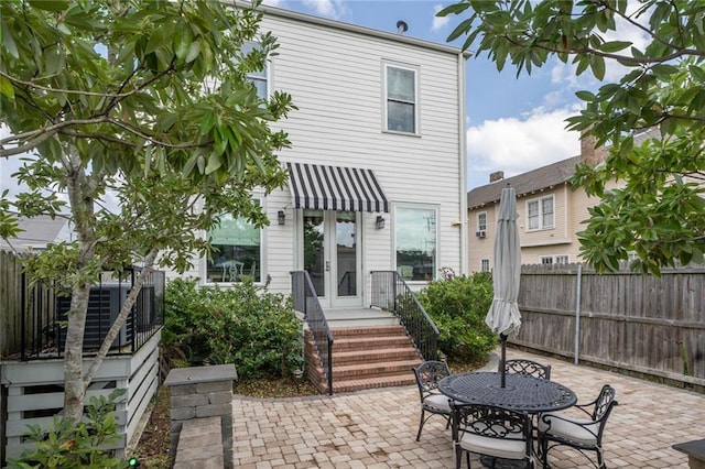 back of house with fence, outdoor dining area, french doors, and a patio