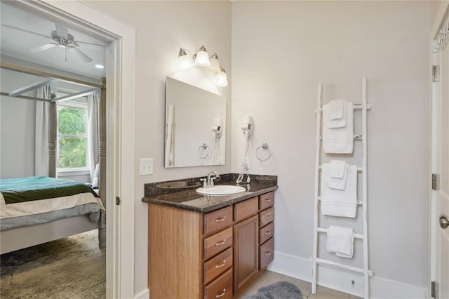 ensuite bathroom with vanity, baseboards, a ceiling fan, tile patterned floors, and ensuite bath