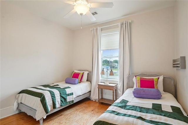 bedroom with visible vents, ceiling fan, baseboards, and wood finished floors