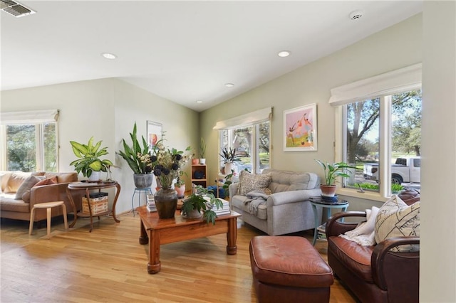 living area featuring light wood-style floors, a wealth of natural light, and visible vents