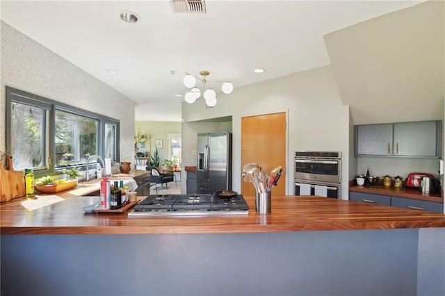 kitchen featuring stainless steel appliances, recessed lighting, visible vents, wooden counters, and a sink