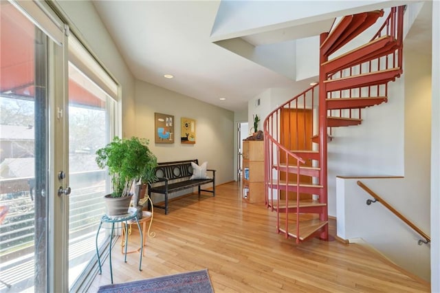 stairway with wood finished floors and recessed lighting