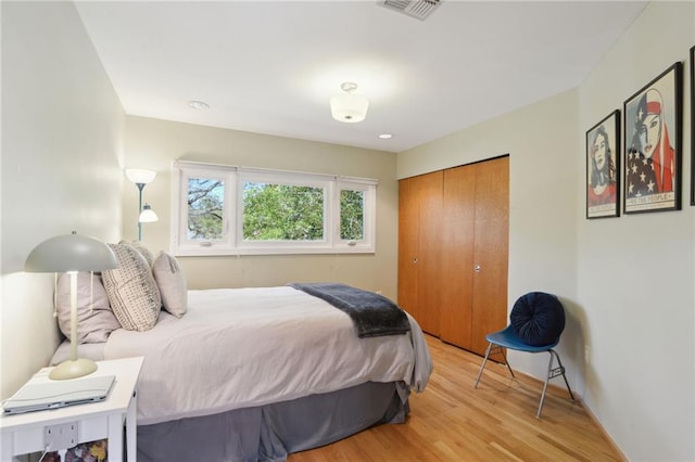 bedroom featuring a closet, visible vents, and light wood finished floors