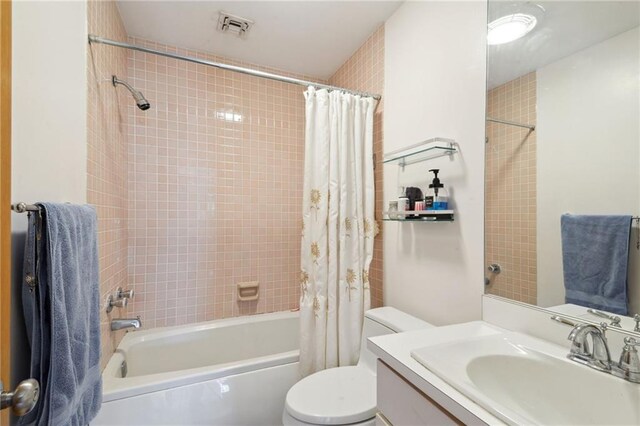 bathroom featuring shower / tub combo, visible vents, vanity, and toilet