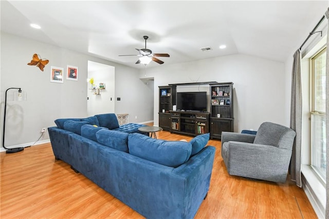 living area with lofted ceiling, baseboards, visible vents, and light wood-style floors