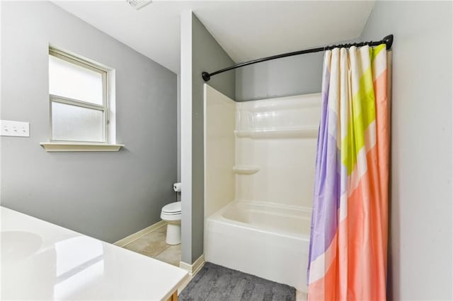 full bath featuring shower / bath combination with curtain, toilet, vanity, baseboards, and tile patterned floors