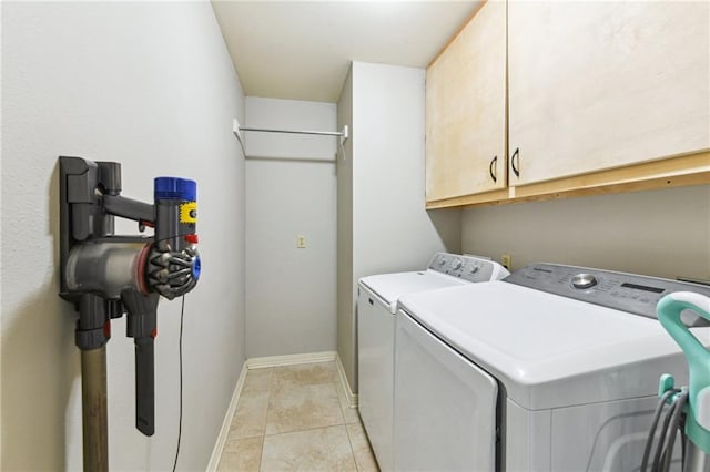 washroom featuring light tile patterned floors, cabinet space, baseboards, and separate washer and dryer