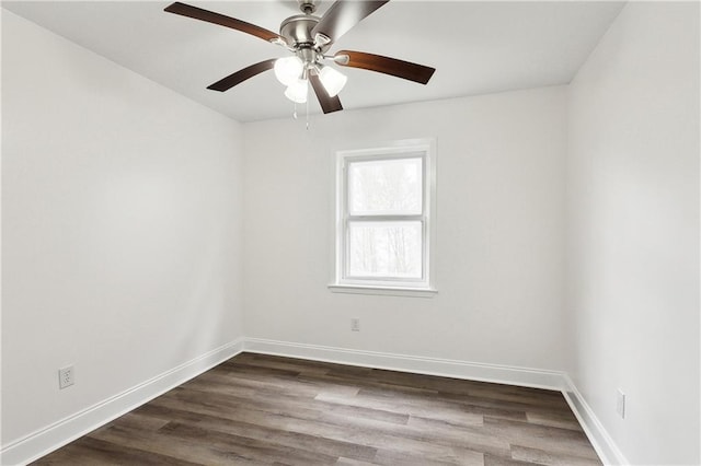 spare room with dark wood-style flooring, ceiling fan, and baseboards