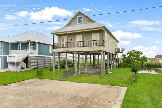 back of house with concrete driveway, stairway, a carport, and a yard