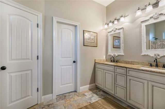 278 Lakeview Dr, Slidell, LA 70458 - bathroom featuring stone finish floor, a sink, baseboards, and double vanity