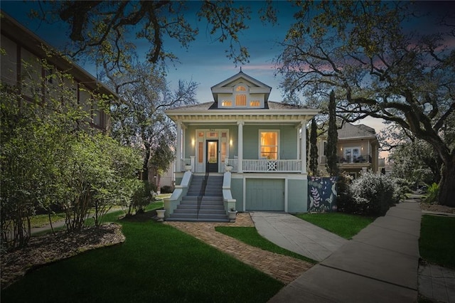 view of front of property featuring covered porch, a yard, an attached garage, and stairs