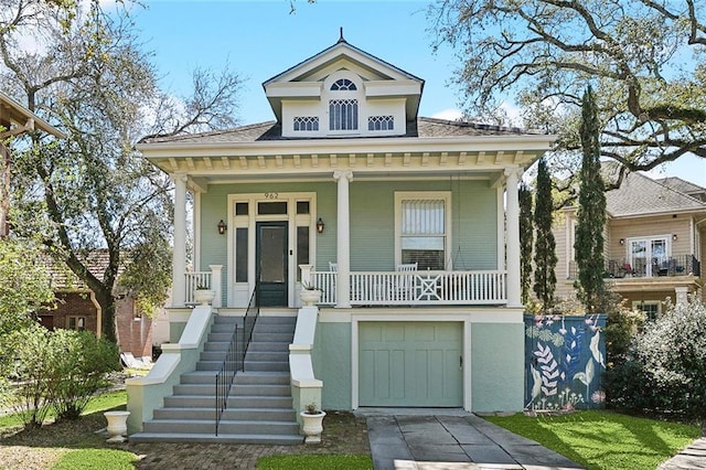 view of front of house featuring a porch, concrete driveway, stairway, and a garage