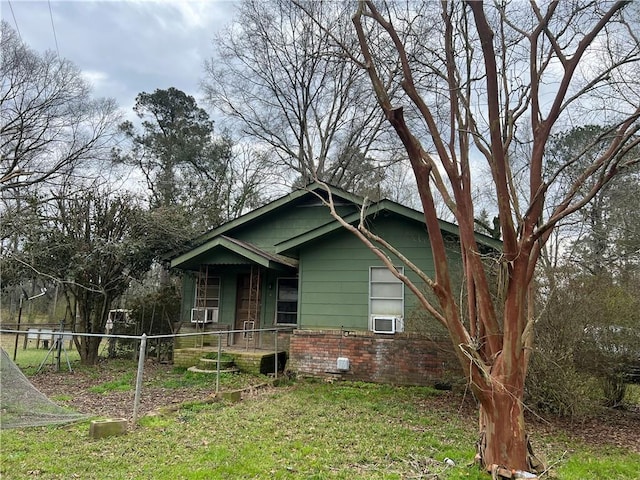 view of front of property with covered porch, fence, cooling unit, and brick siding