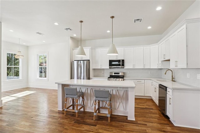 kitchen featuring appliances with stainless steel finishes, a sink, visible vents, and decorative backsplash