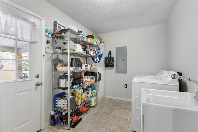 clothes washing area with a textured ceiling, light tile patterned floors, washing machine and dryer, laundry area, and electric panel