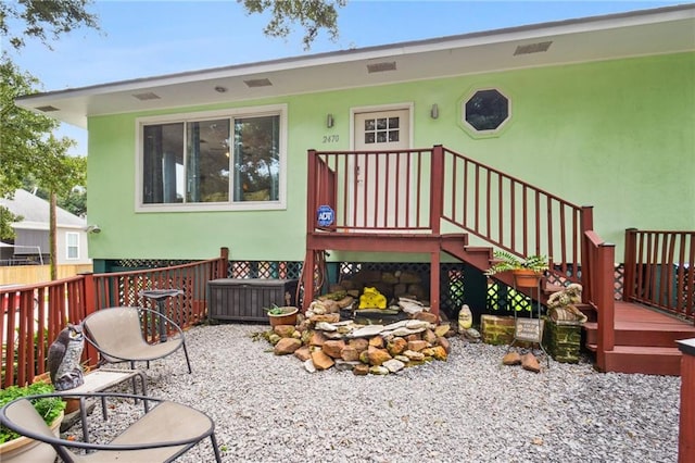 back of house featuring fence and stucco siding