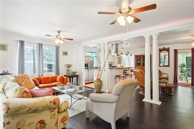 living area with ceiling fan, wood finished floors, and decorative columns