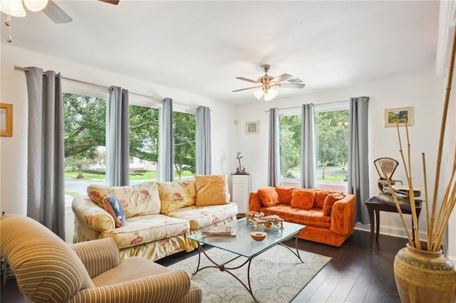 living area featuring wood-type flooring, baseboards, and ceiling fan