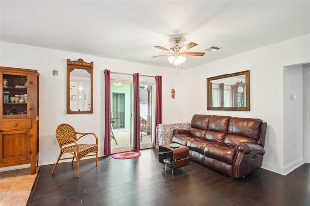 living area with ceiling fan, visible vents, baseboards, and wood finished floors