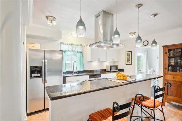 kitchen featuring island range hood, appliances with stainless steel finishes, a kitchen breakfast bar, white cabinetry, and a sink