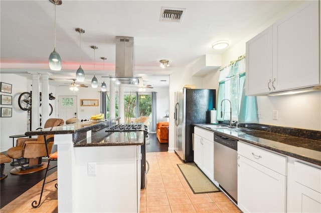 kitchen featuring island exhaust hood, a breakfast bar area, stainless steel appliances, visible vents, and a sink