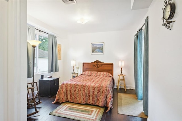 bedroom featuring wood-type flooring, visible vents, and baseboards