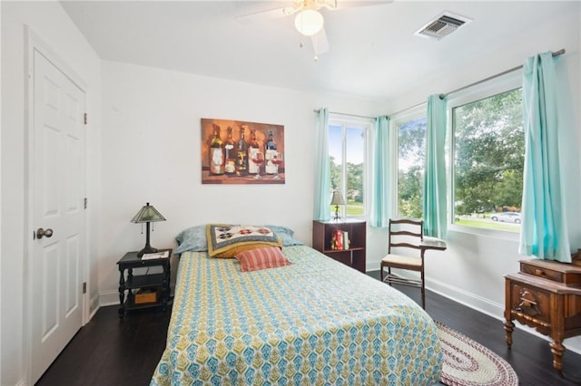 bedroom with visible vents, dark wood finished floors, and baseboards