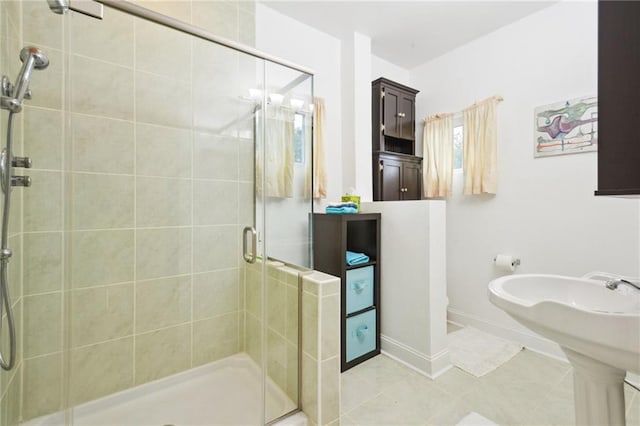 full bath with a shower stall, baseboards, and tile patterned floors