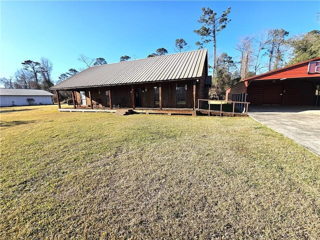 view of front of property with driveway, metal roof, and a front lawn