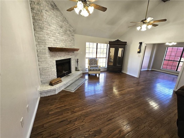 unfurnished living room featuring high vaulted ceiling, a brick fireplace, baseboards, and hardwood / wood-style flooring