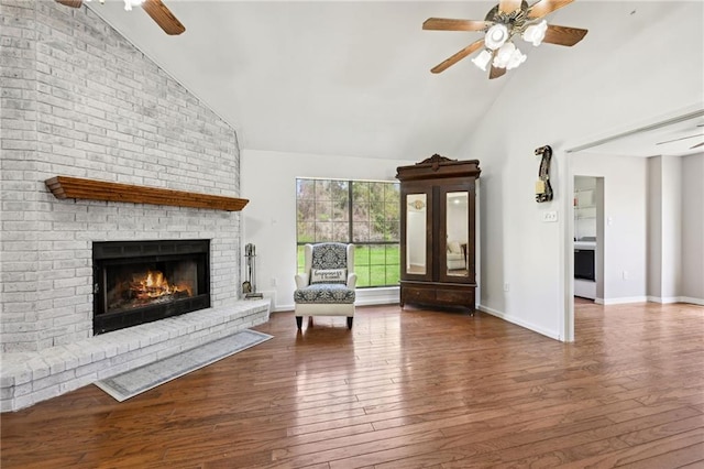 16685 Meissner Rd, Springfield, LA 70462 - unfurnished living room featuring high vaulted ceiling, hardwood / wood-style flooring, a ceiling fan, a brick fireplace, and baseboards