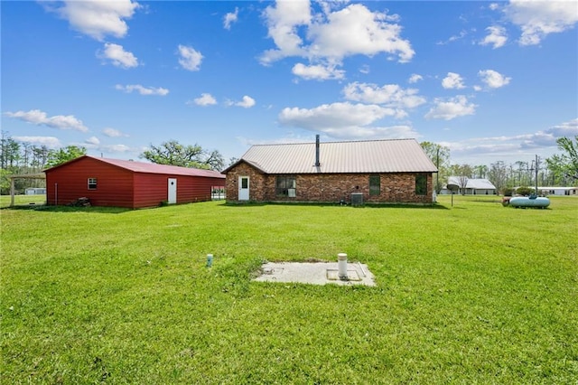 16685 Meissner Rd, Springfield, LA 70462 - rear view of house with a lawn, metal roof, and central air condition unit